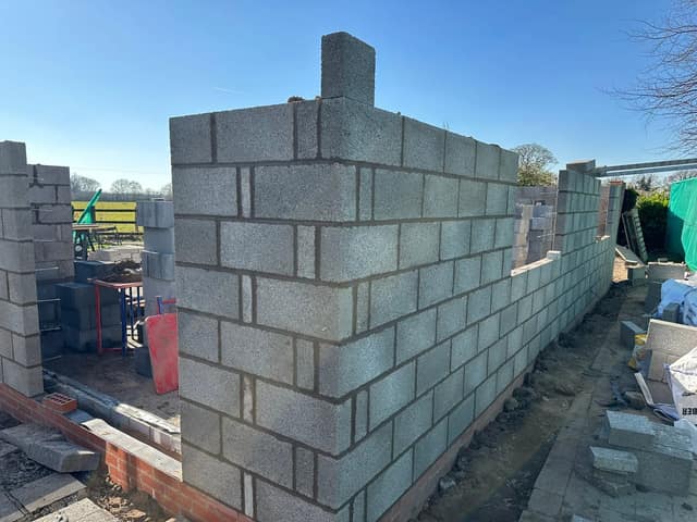 Blockwork inner leaf of a new extension going up, with courses squared off ready for the outer brick skin