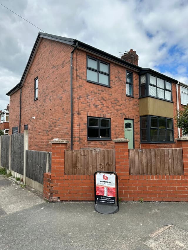Completed two-storey side extension in red brick with anthracite windows and a rebuilt front garden wall